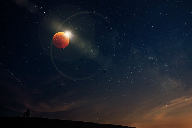 Eclipse lunar acontecendo; a Lua está vermelha