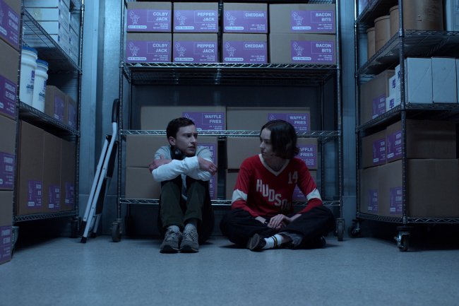Sam e Casey em cena da quarta temporada de Atypical; os dois estão sentados em um deposito conversando; Sam está abraçado os joelhos na frente do corpo enquanto Casey o encara