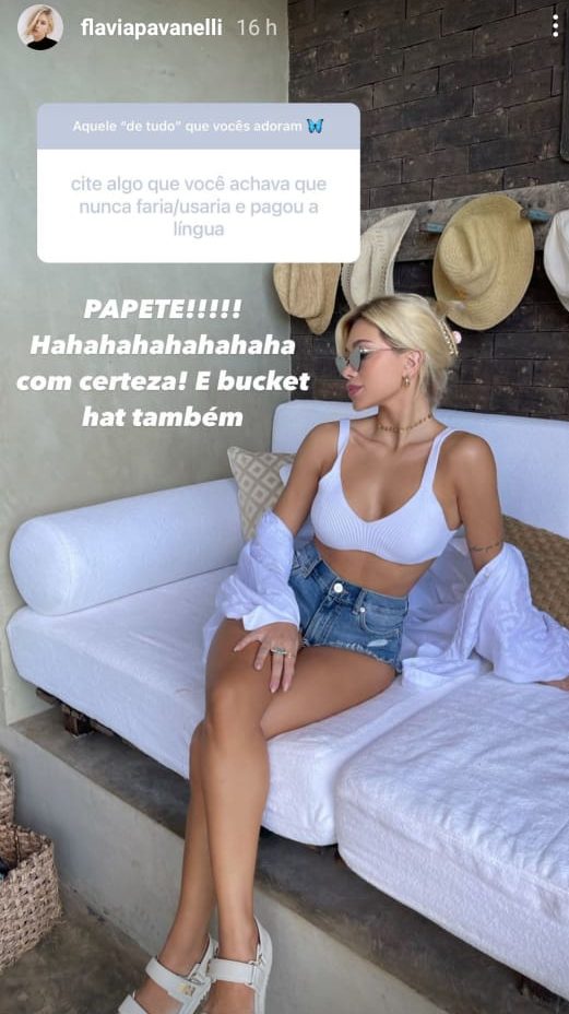 Print do instagram de Flavia Pavanelli posando em uma foto sentada em um sofá branca, top, camiseta, short, usando coque e sentada virada para o lado direito.