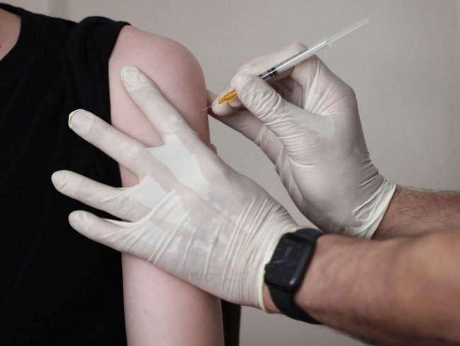 Adolescente recebendo a vacina contra a COVID-19 no braço