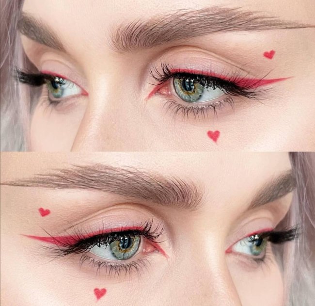 Imagem com foco no olhar de uma jovem que usa maquiagem com delineado rosa e coração pequeno no canto do olho.