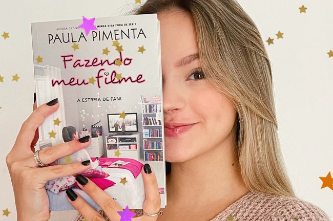 Bela Fernandes holding the book Making My Film and hiding half her face behind it;  she is smiling lightly with light makeup and black painted nails on a white/neutral background;  yellow, orange and lilac stars decorate the image
