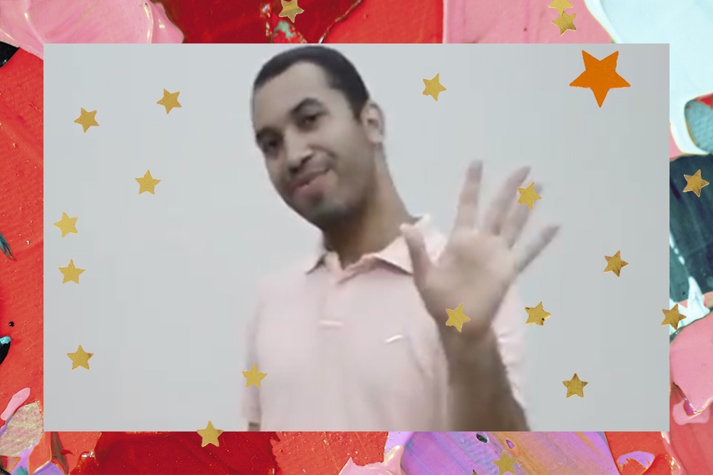 Print de Gilberto em vídeo de inscrição, ele usa uma camisa rosa clara e está acenando para câmera em frente de uma parede branca; a margem é uma textura de tintas em tons de vermelho, rosa, roxo e amarelo com estrelas amarelas e laranjas decorando a imagem
