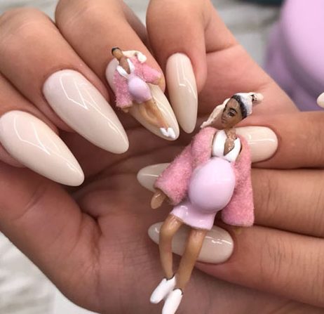 Foto com destaque nas unhas que estão com nail art inspirada em ovos quebrados inspirada na Khloe Kardashian grávida.