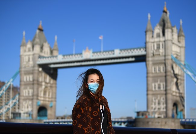 Mulher com máscara posa na frente da Tower Bridge, em Londres