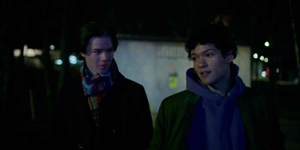 Wilhelm e Simon em cena de Young Royals; eles estão andando na rua de noite com roupas de frio enquanto conversam