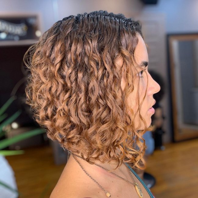 chanel de bico ondulado Foto de uma mulher de perfil mostrando o corte chanel de bico em seu cabelo ondulado.