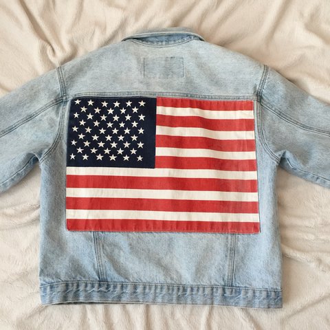 Foto de uma jaqueta jeans com a estampa da bandeira dos Estados Unidos nas costas.