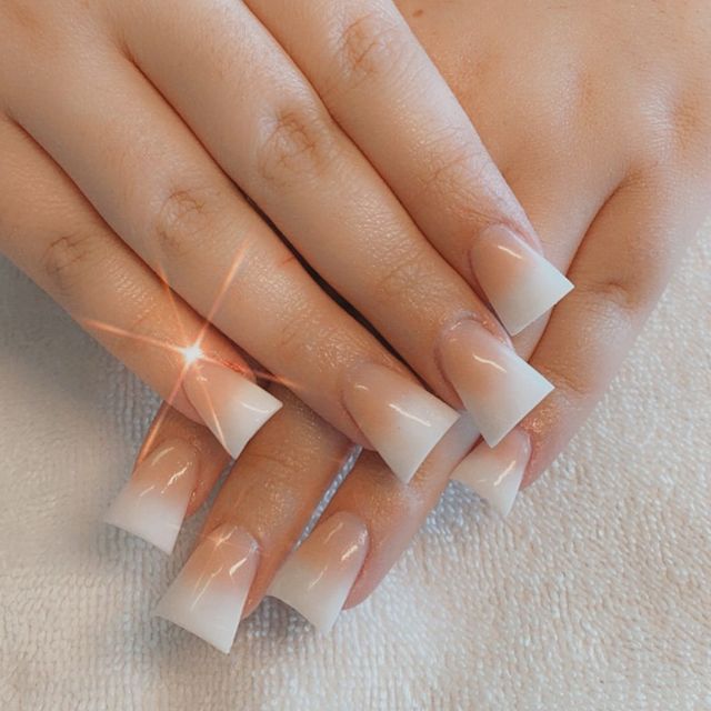 nail duck feet Foto com foco nas unhas com formato duck feet. As unhas estão esticadas. Com francesinha branca.