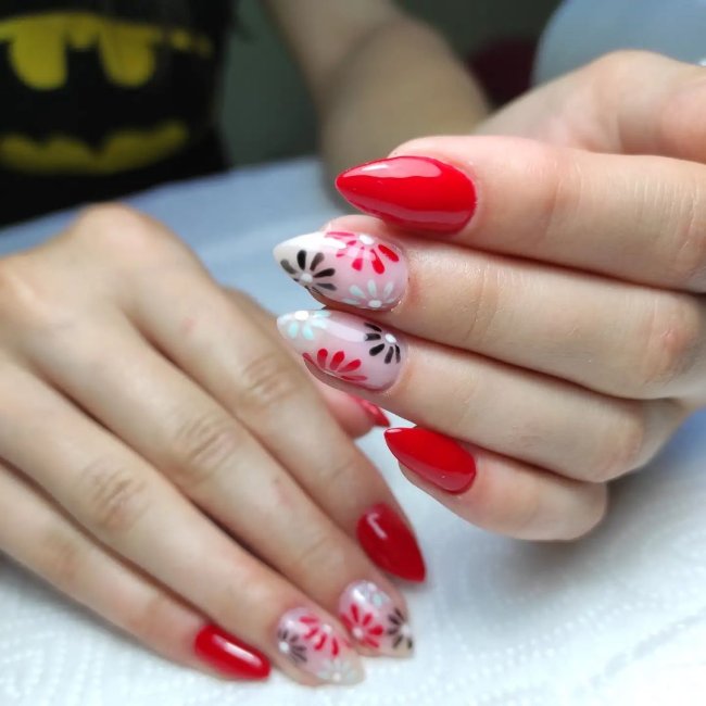 Foto com foco nas mãos exibindo a nail art das unhas. No caso, unha vermelha com detalhe de flores.