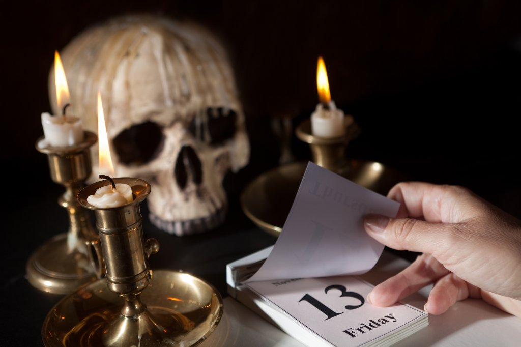 Na foto, um calendário marcando a sexta-feira 13, algumas velas ao redor dele e um crânio ao fundo