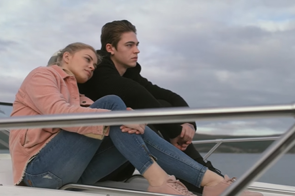 Tessa e Hardin em cena de After - Depois do Desencontro; os dois estão sentados em um barco olhando para o horizonte e Tessa está com a cabeça encostada no ombro de Hardin