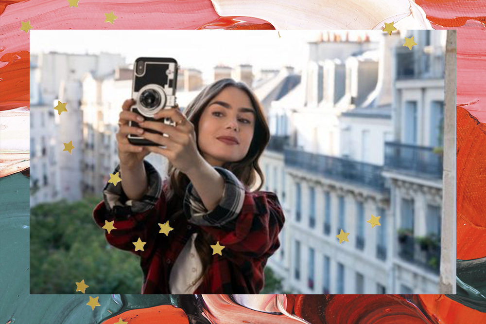 Personagem Emily segurando um celular e fazendo uma selfie. Ao fundo, aparece a cidade de Paris.