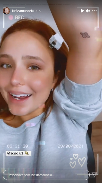 larissa-manoela-nova-tatuagem-saturno Larissa Manoela de braço levantado, mostrando a tatuagem de Saturno próxima ao seu cotovelo