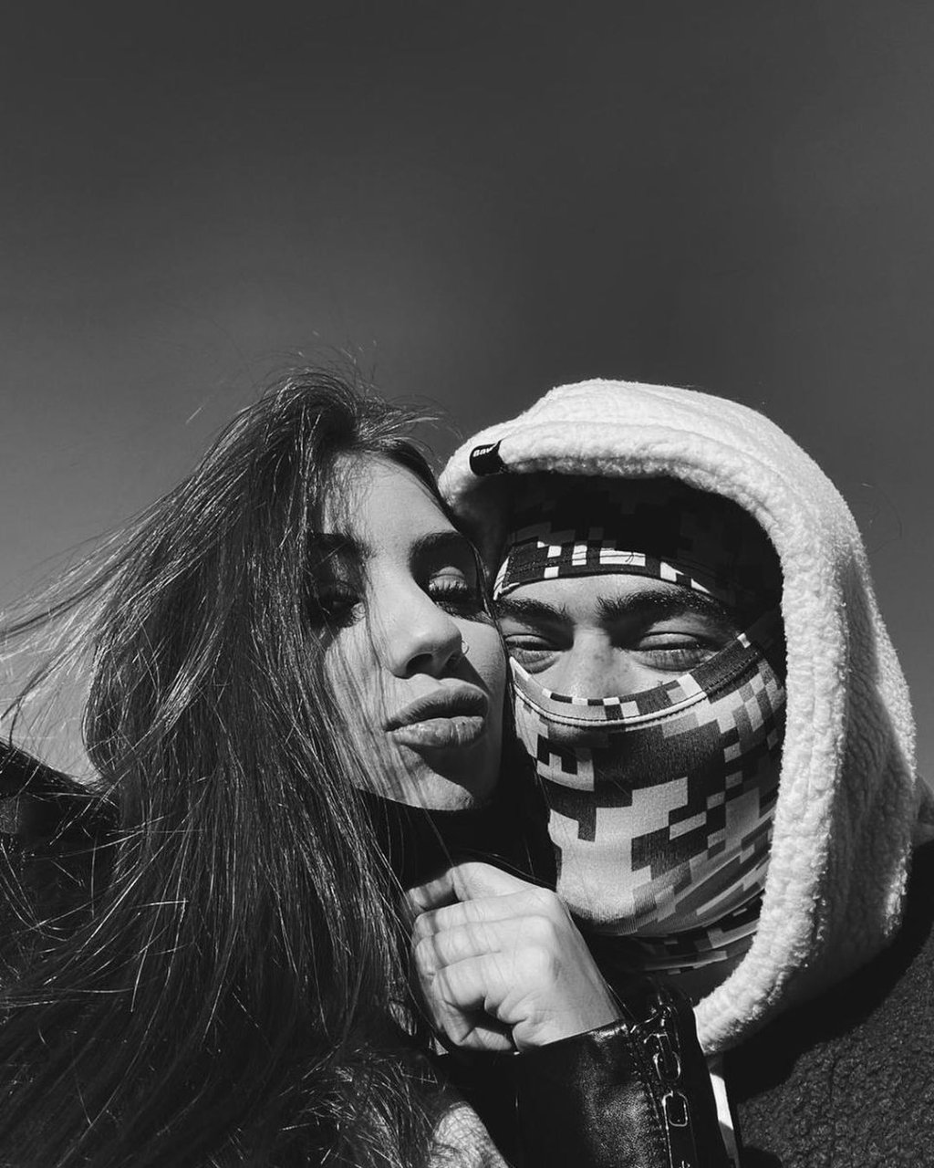 Selfie em preto e branco de Maria Lina e Whindersson Nunes; eles estão com os rostos encostados; Maria está fazendo biquinho enquanto o rosto de Whindersson está coberto por um tecido deixando apenas os olhos visíveis