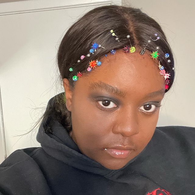 piercing na frente do cabelo Jovem posando com expressão séria para selfie com piercings na parte da frente do cabelo.