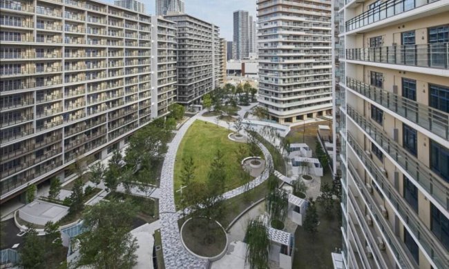 Imagem aérea da Vila Olímpicas de Tóquio 2020. Muitos prédios com uma praça no meio