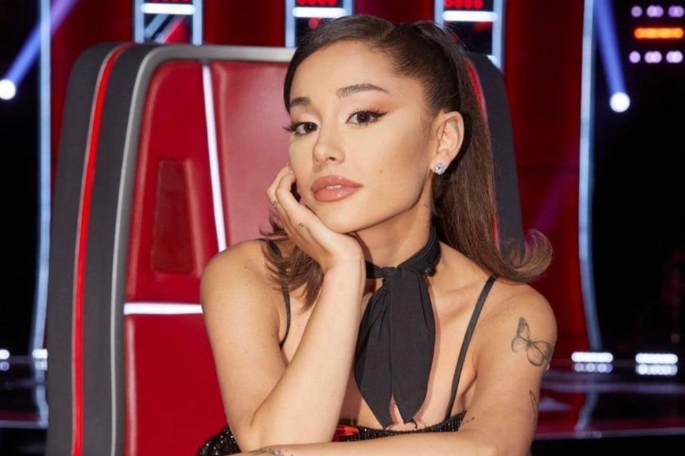 Foto de Ariana Grande sentada na cadeira de jurada do programa The Voice