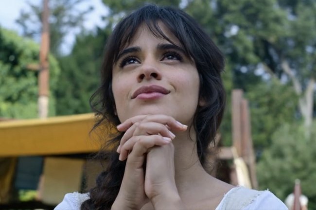 Imagem de Camila Cabello, no papel de Cinderella, olhando para o céu, com as mãos em posição de prece, com feições esperançosas