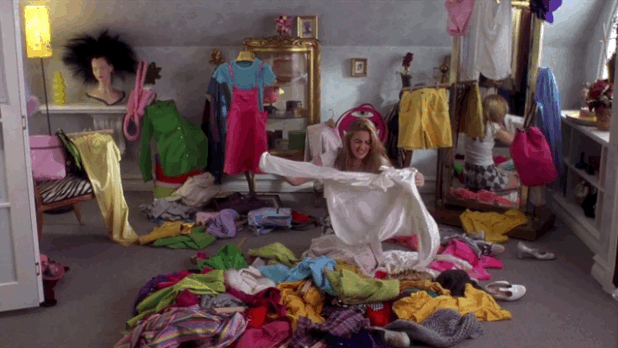 clueless-cher-gif Cher sentada no chão com várias roupas jogadas ao seu redor.