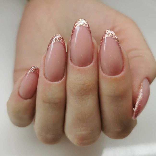 Foto com foco nas unhas feitas com francesinha de glitter.