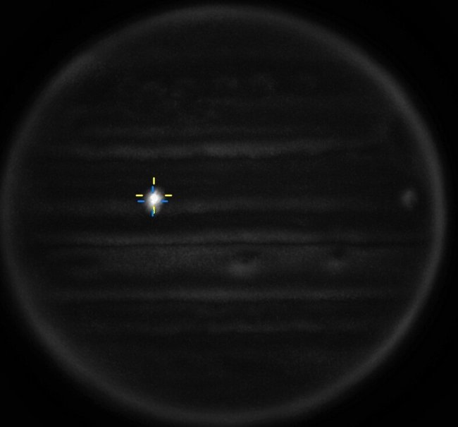 Telescope image of Jupiter's surface.  There is a flash on the top left, indicating an asteroid collision