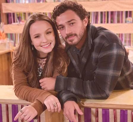 Foto de Larissa Manoela e André Luiz Frambach nos bastidores do filme Modo Avião; eles estão com os rostos próximos sorrindo para a câmera