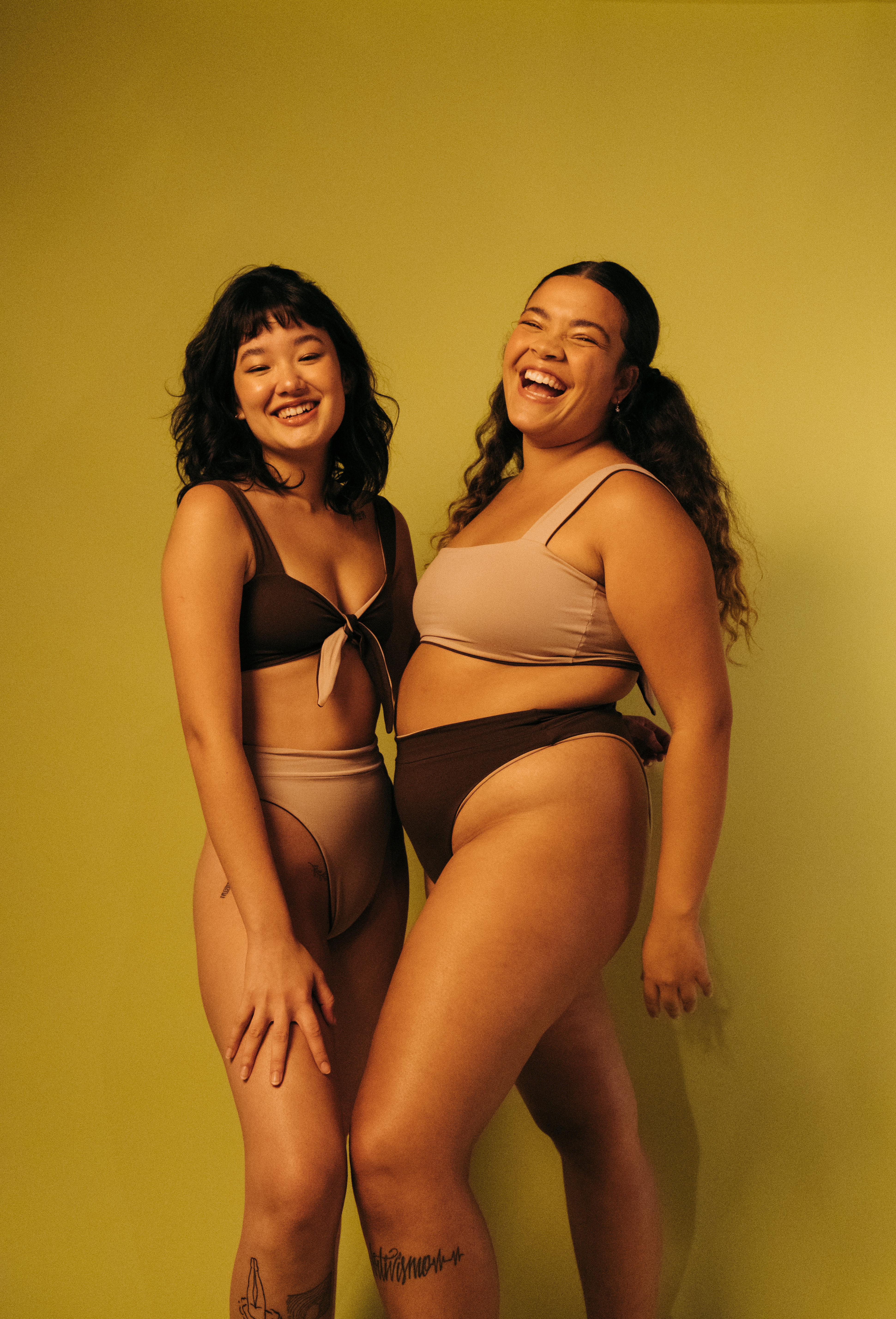 Duas modelos usando biquínis e sorrindo para a câmera