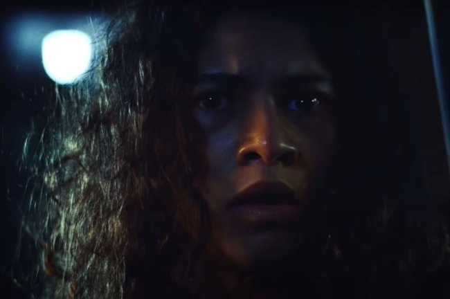Photo of Zendaya, with curly hair and a panic-in-the-dark face.
