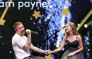 Foto de Liam Payne cantando na festa de 15 anos de Amanda Callegari. Ambos estão sentados em um palco, com as mãos dadas
