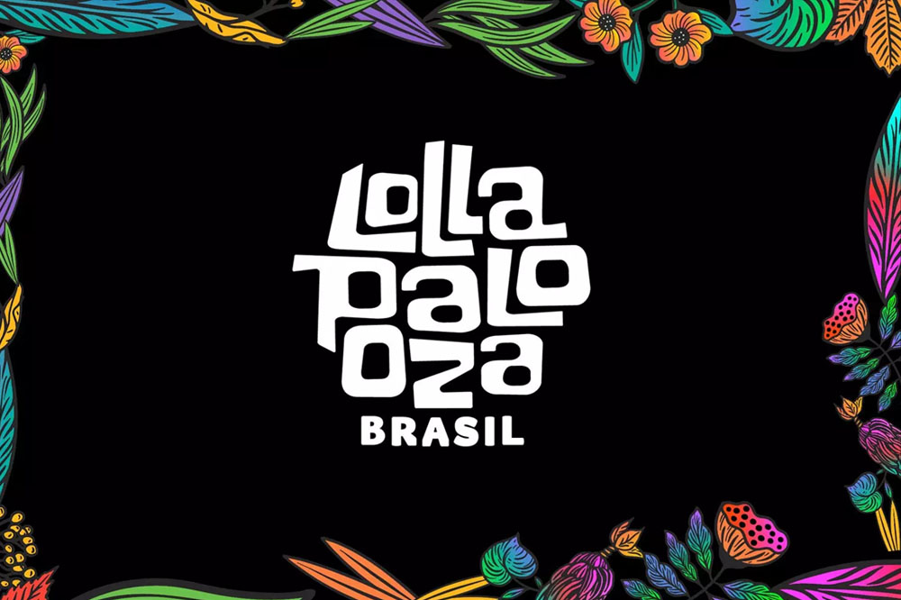 Foto de divulgação do Lollapalooza Brasil. Nela, o logo do festival está em branco no centro, fundo preto e moldura de flores coloridas em volta.