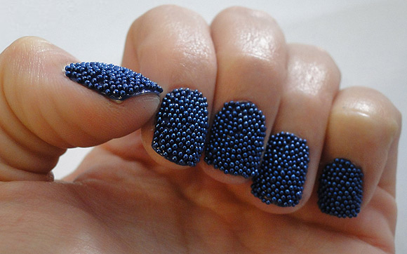 Foto de unhas com decoração de bolinhas 3D azul.