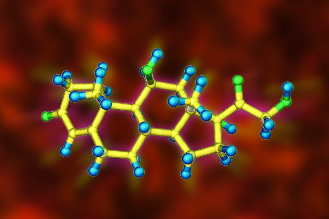 Molde uma uma molécula de cortisol feito no computador. O fundo é vermelho, e a molécula é amarela com pontinhos em verde e azul