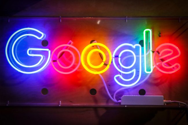 Logo do Google preso a uma parede de cimento. Ele é neon e tudo colorido