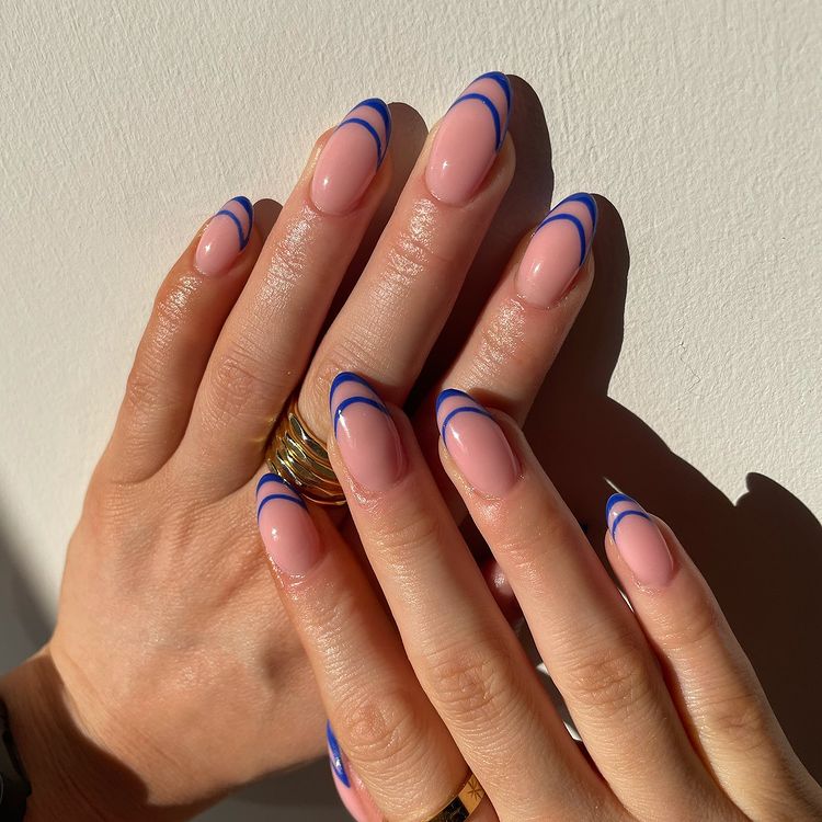 Foto de mãos com as unhas decoradas com francesinha dupla em um tom de azul.