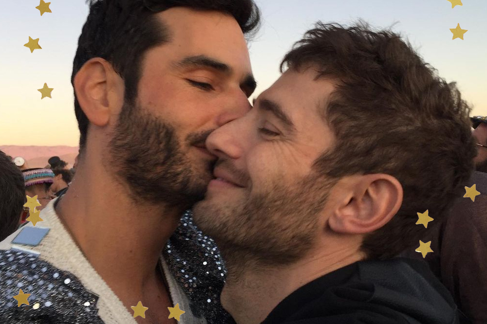 Selfie de Landon Ross e Julian Morris; os dois estão de olhos fechados com os rostos colados enquanto Landon beija o rosto do namorado que está sorrindo levemente; estrelas amarelas decoram a imagem