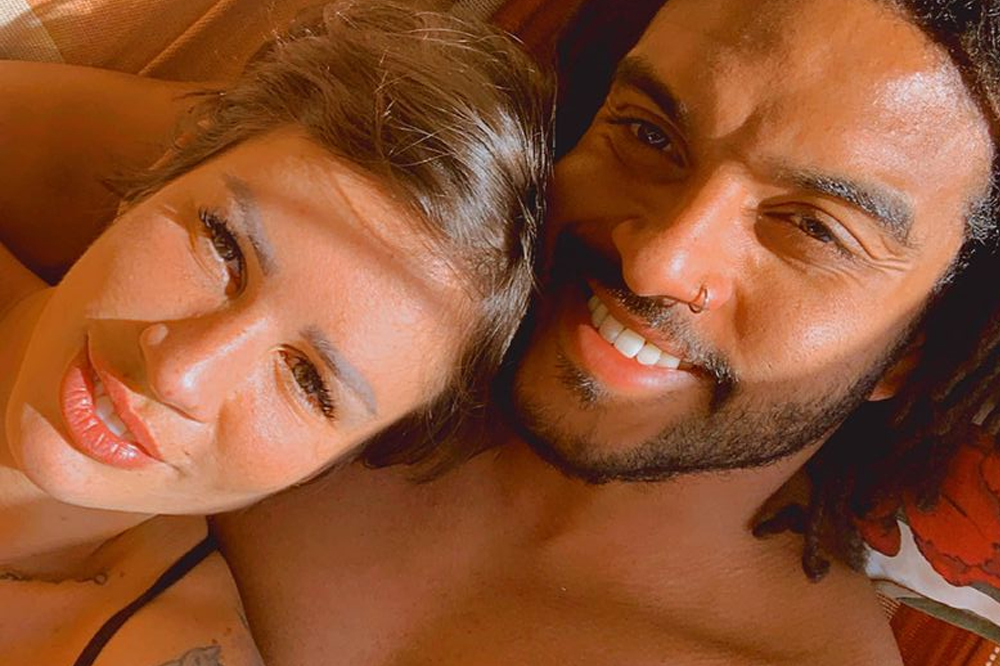 Selfie de Nanda Terra e Mack David, de Casamento às Cegas Brasil; eles estão com os rostos próximos sorrindo para a câmera com roupas de praia e iluminados pelo sol