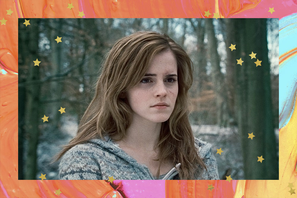 Emma está em um floresta com neve, cabelos soltos e uma jaqueta cinza de zíper.