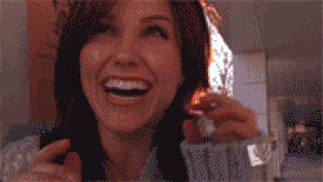 Gif da personagem Brooke Davis sorrindo e comemorando. Ela é branca, possui cabelos castanhos avermelhados e está com uma blusa de magas longas.