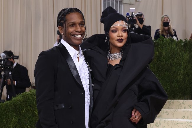 Rihanna and A$AP Rocky no Met Gala 2021; os dois usam roupas pretas e o rapper sorri abertamente enquanto a cantora está sorrindo levemente; os dois posam para foto no tapete vermelho