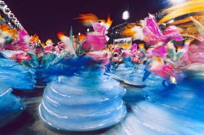 Ala das baianas passando pelo sambódromo Marquês de Sapucaí. Elas vestes roupas azul e rosa.