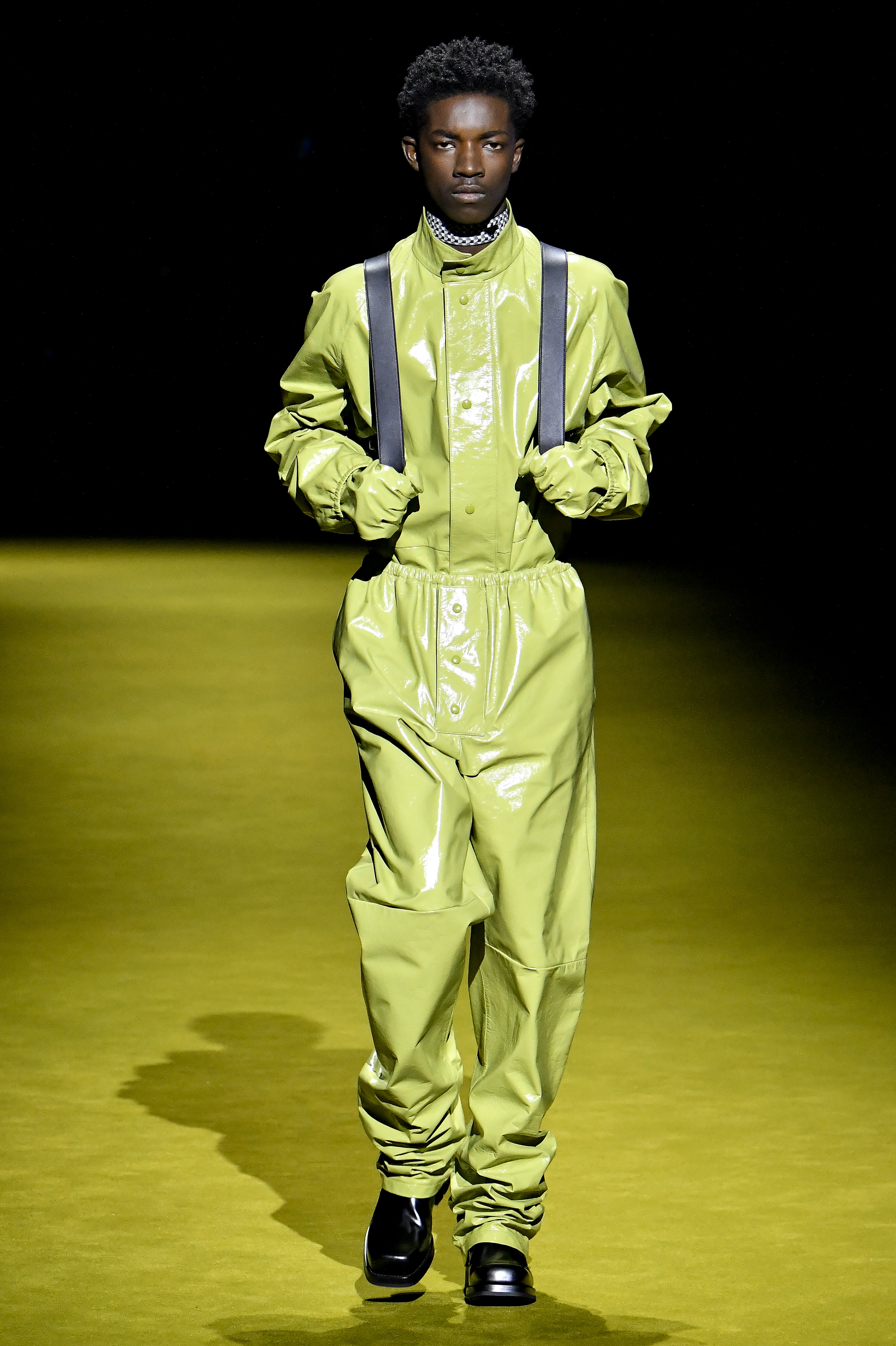 Modelo usando macacão verde em desfile da Prada na semana de moda masculina