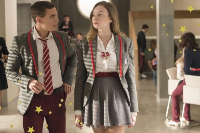 Carla e Miguel em uma cena de Elite no corredor do colégio usando o uniforme.