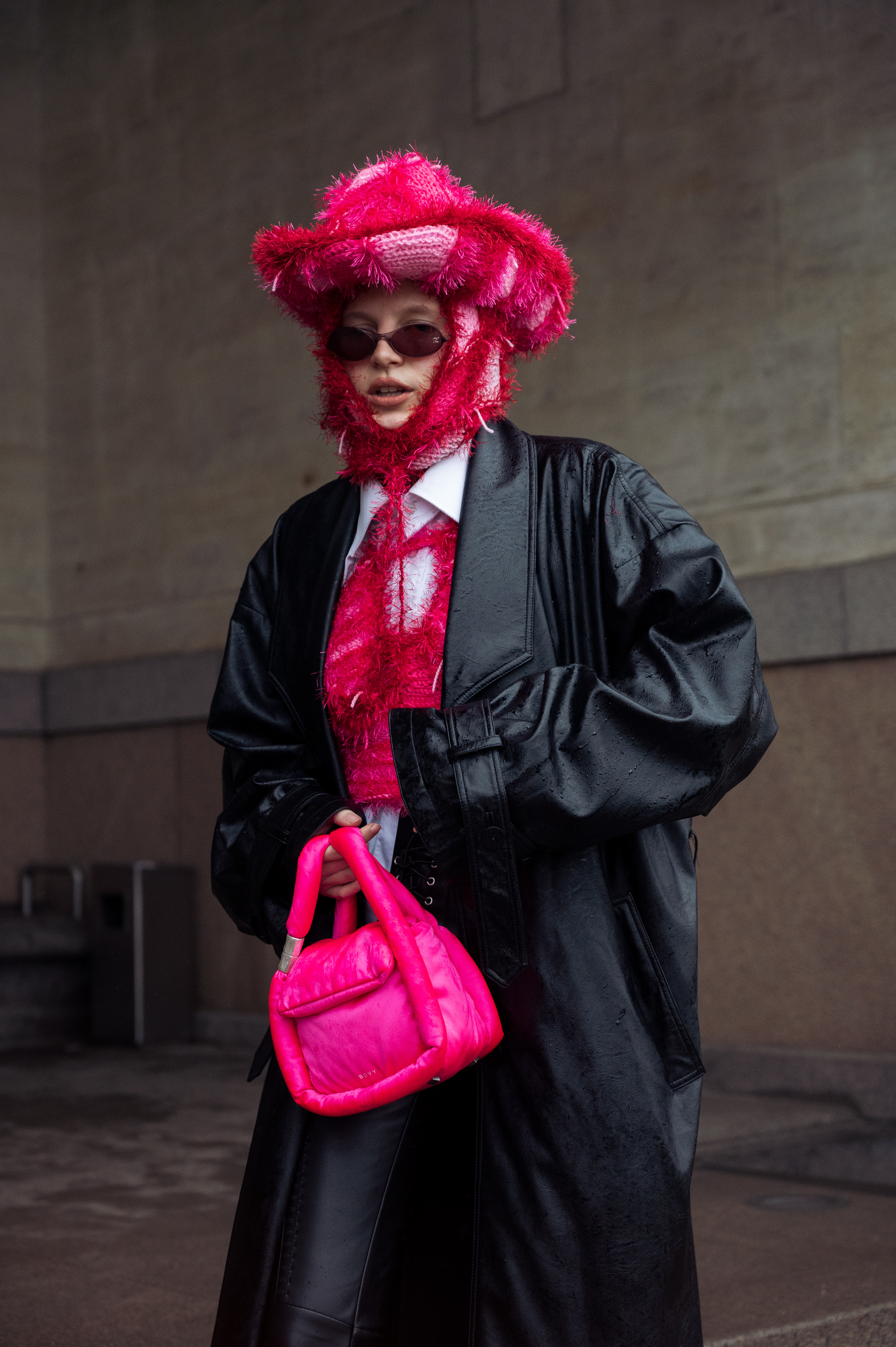 Lotta Lavanti na semana de moda de Copenhagen, na Dinamarca usando chapéu rosa, casaco preto, calça preta e bolsa rosa
