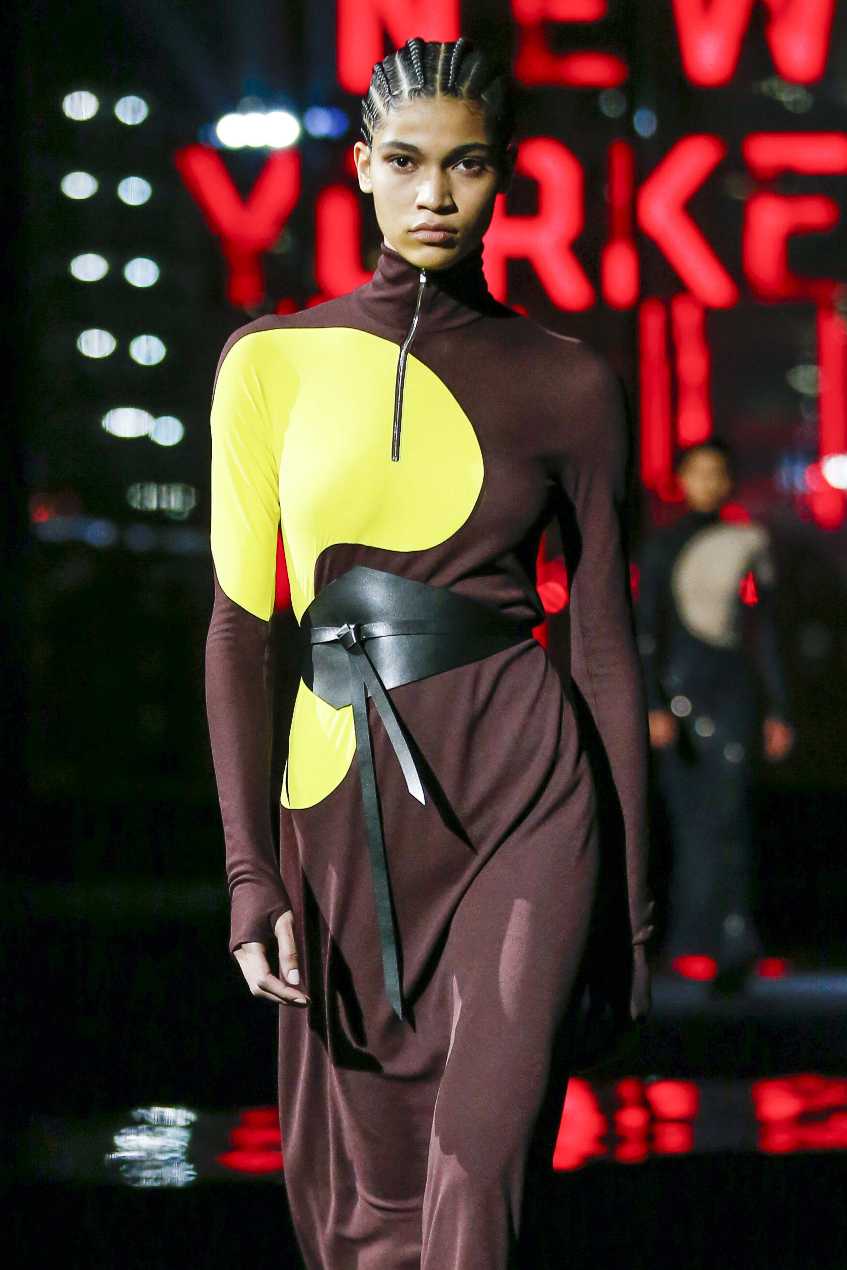 Modelo usando vestido marrom e amarelo com cinto preto em desfile da Tory Burch na semana de moda de Nova York