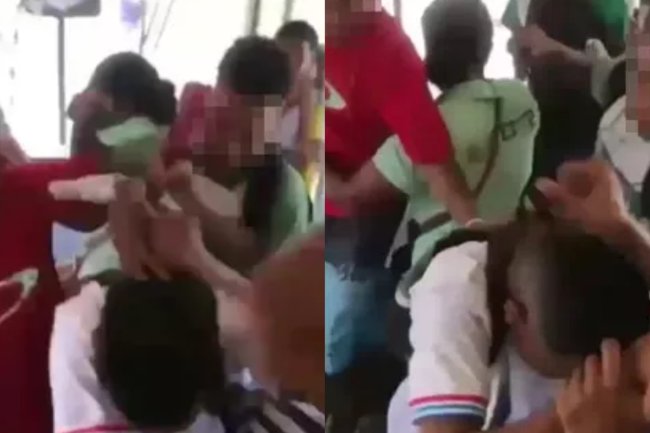 Print do vídeo do momento da agressão. Estão todos dentro de um ônibus, a vítima está de camiseta clara, é um menino negro e está com a cabeça baixa.