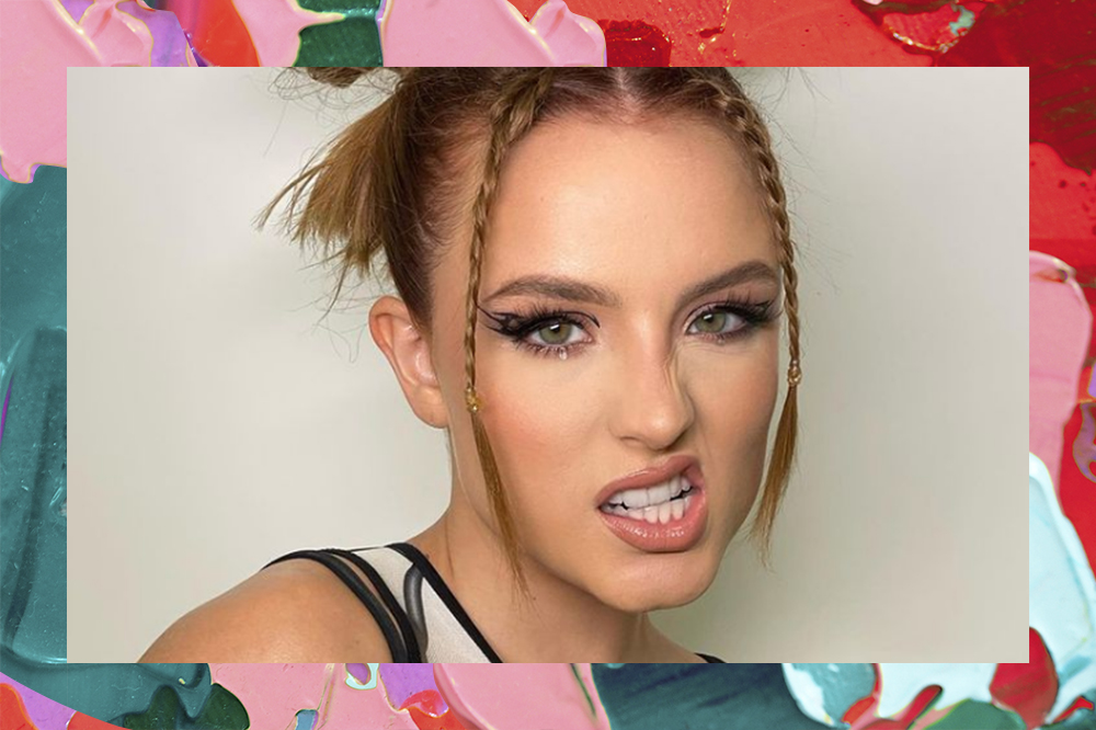 Larissa Manoela usando penteado com space buns e tranças na franja e fazendo careta. O fundo da montagem é colorido