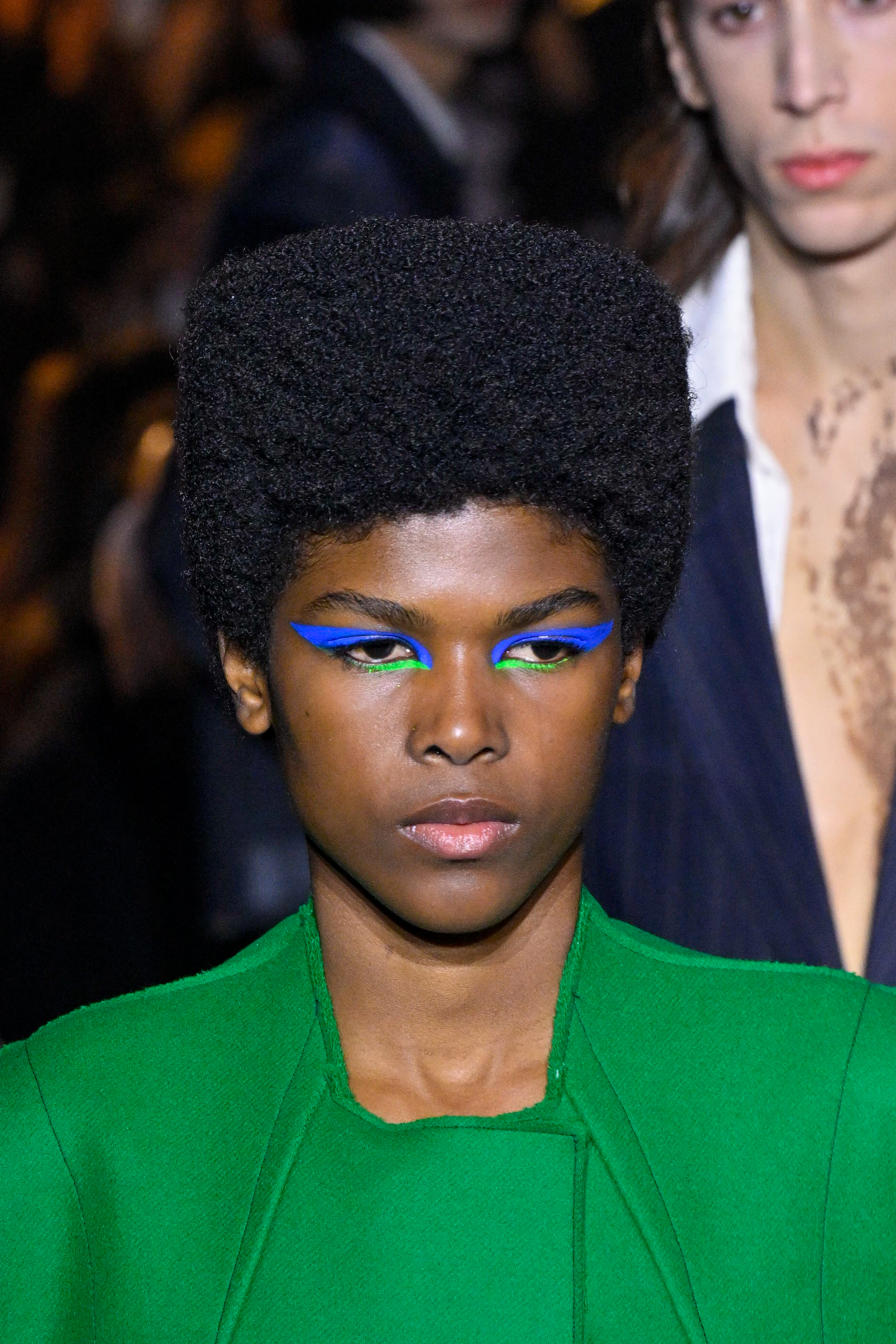 Modelo usando delineado azul e verde em desfile da Capasa Milano na semana de moda de Milão
