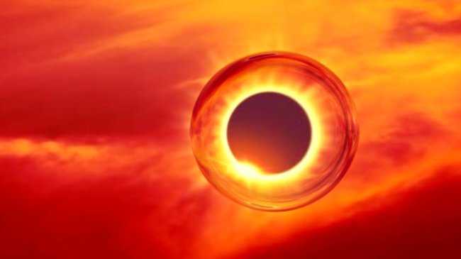 Foto de um eclipse solar. O sol está coberto e o céu está bem laranja