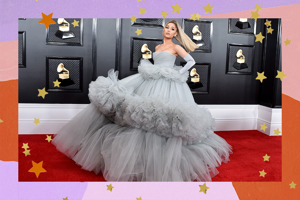 Imagem mostra Ariana Grande posando para foto no tapete vermelho da 62ª edição do Grammy Awards 2020. Ela usa um vestido Giambattista Valli, modelo tomara que caia azul acinzentado com uma saia de tule bem volumosa com detalhes em babados e um par de luvas da mesma cor.